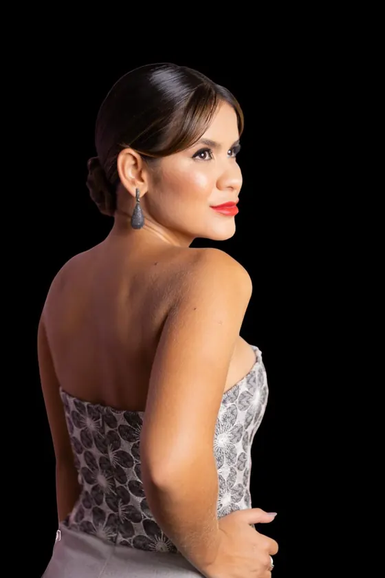 Gabriella Moraes de perfil, sobre fundo escuro